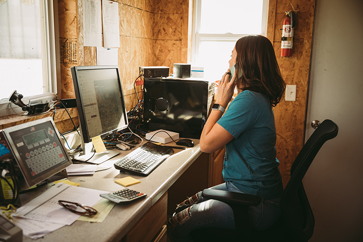 Woman on phone in front of a computer
